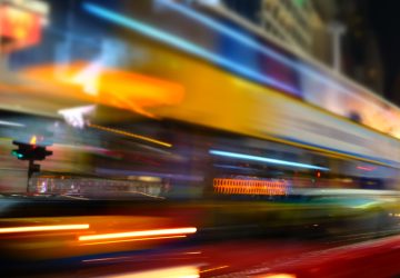 Abstract cityscape blurred background. ight view of modern city street with moving transport and illuminated skyscrapers. Hong Kong