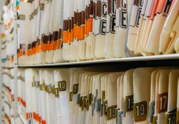 various medical record charts and folders in cabinet and on shelve sorted alphabetically and numerically